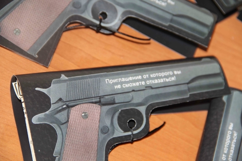 Приглашение пистолеи другие аксессуары для гангстерской вечеринки.